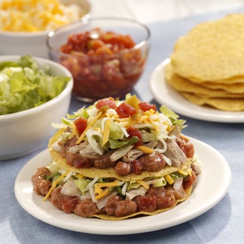 Tostada shells with layers of refried beans, chicken, lettuce, cheese and tomatoes Tostada Stack, Stack Recipes, Tostada Shells, Mexican Food Recipes Appetizers, Ready Set Eat, Mexican Appetizers, Spanish Dishes, Mexican Food Recipes Easy, Kraft Recipes