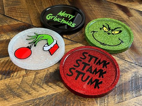 "Grinch inspired Christmas Coasters set of 4- These are amazing and a favorite! Handmade with Love! Pictures do these no justice! I am a stay home mother of 3 who has discovered a love for resin. Set of 4 Coaster Set. Each Coaster comes with a cork bottom   Made with Epoxy Resin, Vinyl Measures 4\" Each coaster differs slightly in design variation due to being handmade and one of a kind. ~HAND WASH ONLY IF NEEDED~ Bulk Pricing available, please send message prior to purchase" Christmas Coaster Ideas, Epoxy Christmas Gifts, Crochet Grinch Coasters, Christmas Resin Coasters Diy, Christmas Epoxy Coasters, Resin Ornaments Diy, Christmas Circle Wood Signs Grinch, Cricut Christmas Ornaments Grinch, Grinch Coasters