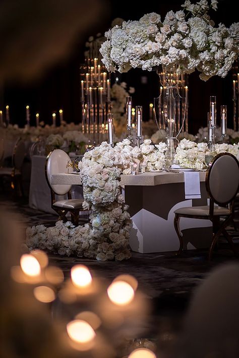 Glowing tapered candles, gold accents and roses dripping from the reception tables decorate the hotel wedding venue's ballroom. | Photo: Chirs Bailey Photography   Spotlight WiH Partner-  Venue, Catering + Cake: The Post Oak Hotel at Uptown Houston   #WeddingsinHouston #RealWedding #HoustonWedding #BallroomReception #ReceptionDecor #WeddingVenues #HoustonVenue #HotelWeddings #LuxuryWeddings #WeddingDetails #BrideToBe #WeddingPlanning #WeddingInspo #WeddingIdeas #Engagement