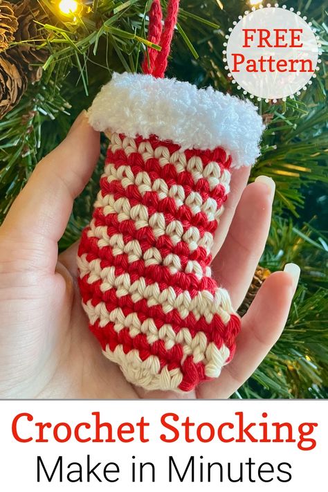 Close up of hand holding a striped crochet mini stocking decoration hanging on Christmas tree Free Crochet Pattern Mini Christmas Stocking, Small Christmas Stocking Crochet Pattern, Mini Stocking Crochet Pattern Free, Small Crochet Stocking Pattern Free, Crochet Small Christmas Stocking, Mini Crochet Christmas Stocking, Crochet Mini Stockings Free Pattern, Mini Christmas Stockings Crochet, Crochet Stocking Ornament