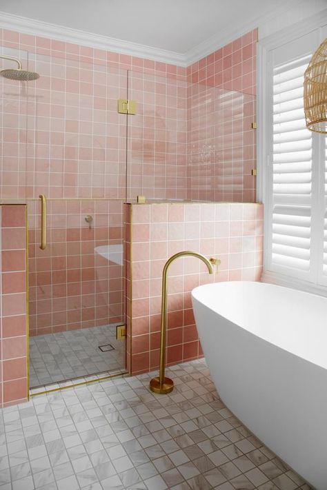 A nib wall in this modern bathroom showcases pink bathroom tiles and brass tapware including a floor-mounted bath filler next to a freestanding bathtub. Square Tile Bathroom, Miami Bathroom, Aesthetic Home Design, Pink Tile Bathroom, White Square Tiles, Pink Bathroom Tiles, Oval Tub, Pretty Bathroom, Hamptons Style Home