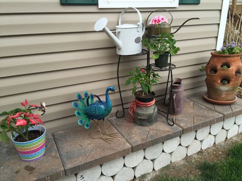 Retaining wall made out of concrete cylinders (that are yet to be painted) and pavers. Concrete Cylinders Ideas, Cement Cylinder Ideas, Shed Landscape, Concrete Garden Bench, Yard Art Ideas, Coturnix Quail, Shed Landscaping, Building A Retaining Wall, Garden Critters