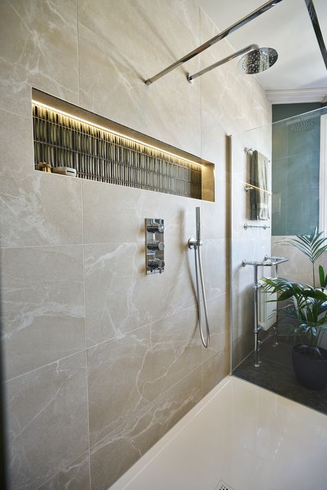 A walk-in, glass-enclosed shower with a waterfall shower head and silver shower fixings with a silver handheld shower head on the wall. The wall has natural stone tiles and a recess with olive green bamboo mosaic tiles. Waterfall Shower Tile, Waterfall Shower Head, Luxury Modern Bathroom, Panelled Walls, Marble Effect Tiles, Natural Stone Tiles, Bathroom Transformation, Waterfall Shower, Green Bamboo