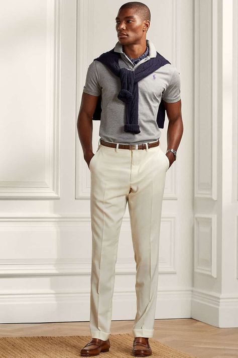 Men's beige pants, grey polo shirt navy sweater and brown leather loafers outfit. This outfit first appeared in the article: 20 Modern Preppy Outfits For Men: How To Get The Ivy League Look In 2022, on MensFlair.com Polo Tucked In Men, Gray Polo Outfit Men, Preppy Outfits For Men, Grey Polo Outfit Men, 80s Outfits For Men, Leather Loafers Outfit, Preppy Work Outfit, Preppy Outfits Men, Bohemian Outfit Men