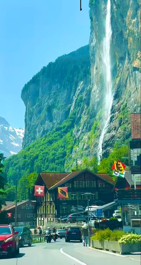 A photo that shows a road rolling through a small Swiss village with one of the Swiss Alps in the background. Switzerland Alps Aesthetic, Swiss Alps Aesthetic, Swiss Alps Photography, Switzerland Village Aesthetic, The Swiss Alps, Swiss Alps Villages, Swiss Village Alps Switzerland, Swiss Village, Very Interesting