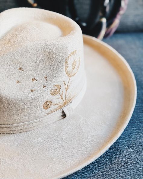 ——— W I S H I N’ A W A Y ——— Meet the newest hat to join the lineup! This dreamy ivory faux suede rancher features a delicate hand-burned dandelion design on the crown, capturing the magic of wishes in the wind. Complete with a pencil rolled brim and a custom decorative band, it’s the perfect piece to carry a bit of whimsy with you. ——— #WishinAway #HatDrop #FauxSuedeStyle #HandcraftedHats #DandelionDreams #FestivalFashion #HalAtTheMoon #UniqueAccessories #MakeAWish Pencil Roll, Dandelion Designs, Painted Hats, A Pencil, Make A Wish, The Crown, Festival Fashion, The Wind, Faux Suede