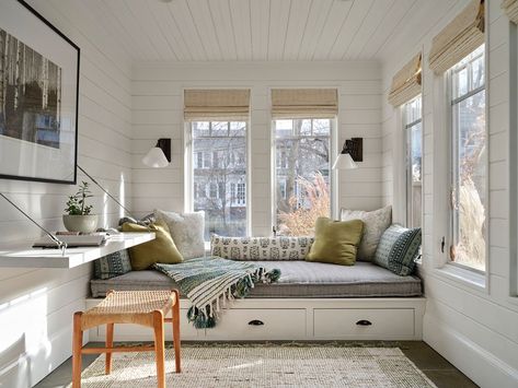 Does anyone else love a good window nook? 🙋🏼‍♀️ I'm living for the soft fabrics and cozy vibes in our sunroom. Storage beneath the futon provides extra space for so many different things, from toys to games, extra linens (this functions as an extra guest room too!), while the accordian style pendant lights are perfect for reading under soft light. Photography: @erinlittlephoto #meghanshadrickinteriors #readingnook #sunroom #workspace #relaxathome #architecturaldesign #architecturalinspirat... Sofa Bed Sunroom, Tiny Sunroom Cozy, Large Window Reading Nook, Sun Reading Room, Glass Reading Room Sunrooms, Built In Daybed, Boston Interiors, Window Nook, Indoor Patio