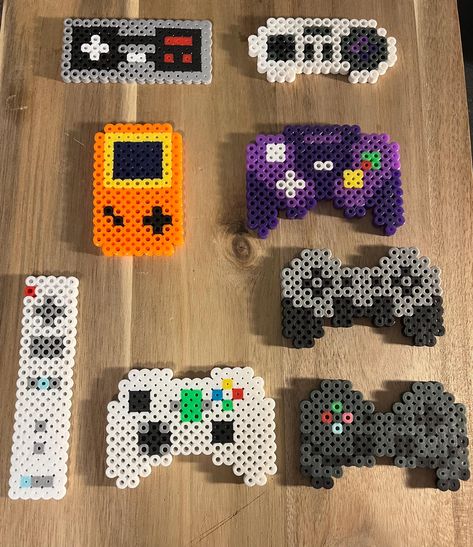 These are keychain sized video game controller designs made of Perler beads! Golf Perler Beads, Gaming Perler Bead Patterns, Perler Art Ideas, Science Perler Beads, Perler Beads Sports, Kc Chiefs Perler Beads, Fortnite Perler Beads, Perler Beads Gaming, Nintendo Perler Bead Patterns