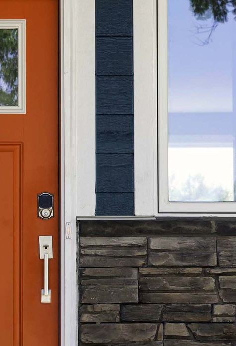 Dark blue siding with an orange front door and real stone veneer Blue And Orange Exterior House Colors, Rust Front Door Colors, Front Door Colors For Dark Blue House, Dark Orange House Exterior, Front Door Colors With Dark Blue Siding, Orange Front Door Blue House, Dark Orange Front Door, Houses With Orange Doors, Blue House Orange Door