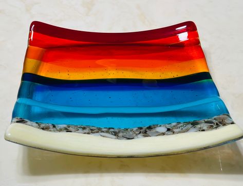 "Fused glass beach sunset plate with French Vanilla for the sand, White and Brown for the rocks by the water, Turquoise and Blue for the ocean waves, and Yellow, Orange, Red sunset skies. This dish has an additional layer of clear glass on the back for a more elegant look and for creating the beautiful bubbles effect. Please note that all my items are Handmade so there may be slight color and / or design variations. A beautiful plate, reminds me of my favorite place to be! Perfect for decorati Fused Glass Sunset, Fused Glass Beach, Beach Dessert, Ocean Soap, Sunset Skies, Fused Glass Dishes, Glass Fusing Projects, Fused Glass Ornaments, Glass Beach