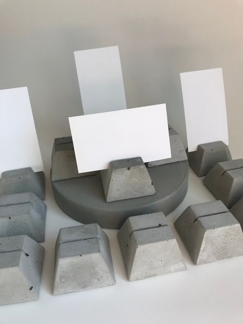 "Place Card Holders made from concrete for party table, dinner party, wedding table decor. For large quantities please allow 1 week lead time. 31mm High x 49mm Wide x 49mm Long 1.25\"H x 1.75\"W x 1.75\"L The card holder slot is 1/16\" wide." Concrete Wedding Decor, Wine Cork Place Card Holder, Concrete Wedding, Wine Theme Wedding, Cement Table, Dinner Party Wedding, Mid Century Modern Lamp, Stone Sign, Table Dinner