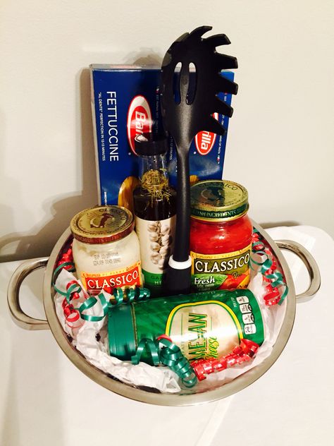 Perfect gift basket for any occasion. Fettuccine pasta, spaghetti pasta, Alfredo sauce, marinara sauce, spiced oil, parmesan cheese, pasta spoon, all inside of a pasta strainer! #christmasgift #giftidea Spaghetti Basket Ideas, Spaghetti Gift Basket Ideas, Pasta Basket Ideas, Pasta Night Basket, Pasta Gift Basket Ideas, Softball Basket, Pasta Gift Basket, Dinner Gift Basket, Italian Gift Baskets