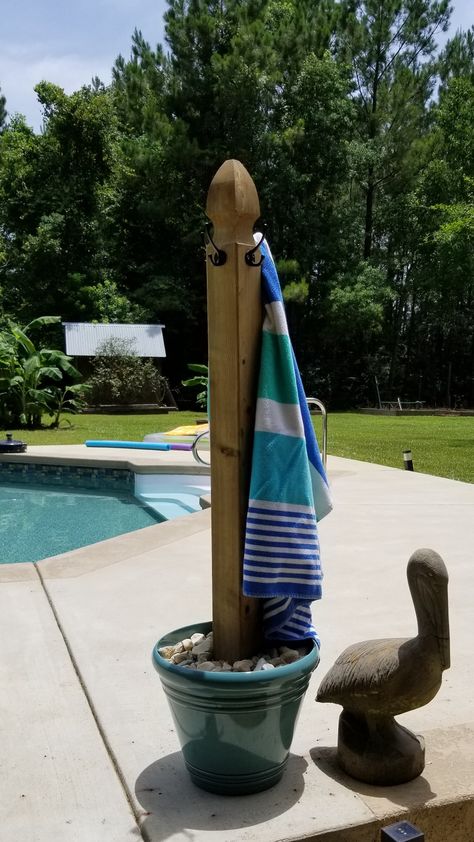 Pool Towel Stand I made for my stepdad. It's a fence post from Lowe's I attached some hooks to and placed in a flower pot with a few inches of quick-create in the bottom to hold it up but not be too heavy so it would be easy to move. I then put some sand on top of quick-create and rocks on top of sand for looks. Outdoor Towel Hooks Hot Tubs, Diy Towel Holder For Pool, Towel Hanger For Pool Area, Towel Rack Hot Tub, Towel Hooks For Pool Area, Pool Yard Decor Backyard Ideas, Pool Caddy Ideas, Pool Accessories Storage Ideas, Towel Holder For Pool Area