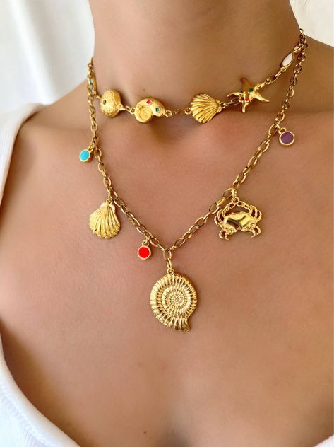 Experience the perfect combination of beachy charm and Greek craftsmanship with our Gold Summer Shell Necklace. Made with vibrant enamel stones and durable stainless steel chains, these handmade necklaces embody the essence of summer. The shorter one is designed as a choker, while the longer one features a stunning gold shell charm at the center. Whether worn together or separately, these necklaces are a must-have for any summer lover. Only available at Christina Christi Store. MATERIALS - Metal Handmade Necklace Tutorial, Maximalist Jewelry, Rebecca Black, Beach Necklace, Beach Necklaces, Handmade Wire Jewelry, Shell Necklace, Girly Jewelry, Shell Pendant