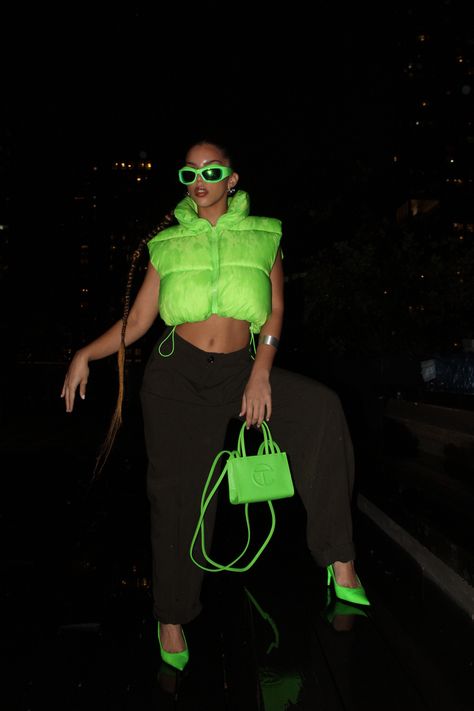 Neon puffer vest, olive green slacks, neon green pointed kitten heels, neon green mini Telfar purse, and neon green shades. Hairstyle: long, slicked braided ponytail. Black background Lime Green Black Outfit, Black Neon Outfit, Neon Green Boots Outfit, Neon And Denim Outfits, Lime Green Vest Outfit, Neon Green Heels Outfit, Neon Theme Party Outfit, Black And Neon Outfit, Neon Green Outfit Aesthetic