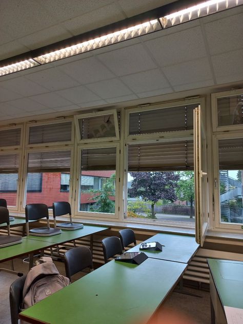 On the picture you can see empty classroom. There are chairs, green tables and window on the background. In window you can see it's evening and raining. Nz School Aesthetic, Classroom Vibes Aesthetic, Rainy School Day Aesthetic, School Studying Aesthetic, Romanticising Winter, Classroom Aesthetic, School Core, Romanticize School, Morning School