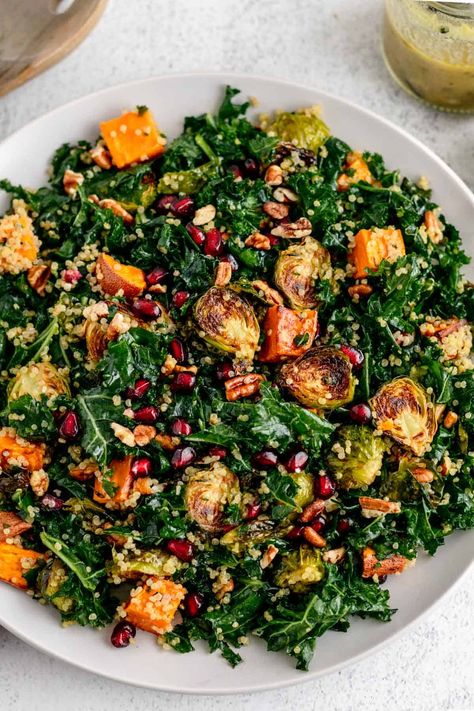 A warm Roasted Vegetable Quinoa Salad with sweet potato, Brussels sprouts, and kale is the perfect healthy and cozy vegetarian dish. This easy salad recipe is tossed with the most delicious honey mustard vinaigrette and served with crunchy pecans and pomegranate for extra flavor and texture. It's a great option for the holidays! Brussel Sprouts And Sweet Potato Recipe, Sweet Potato Brussels Sprouts, Vegan Green Goddess Dressing, Roasted Vegetable Quinoa, Vegetable Quinoa Salad, Vegan Green Goddess, Quinoa Side Dish, Sweet Potato Quinoa Salad, Sprouting Sweet Potatoes