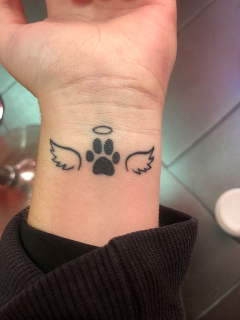 A tattoo with wings a paw print and a halo Tattoos For Women Dog, Tattoo With Dog Paw Prints, Small Black Panther Tattoo, Tattoos Dog Paw, Dog Paws Tattoo Ideas, Dog Halo Tattoo, Tattoo Ideas Paw Print, Tattoo For Lost Dog, Infinity Dog Tattoo