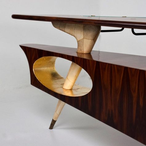 AMBIANIC presenting Custom Sculptural Desk Dry Bar in Rosewood and Parchment Bronze applications designed by FRANK KYLE. Made Mexico circa 1950s. Malachite hardware by PEPE MENDOZA foundry marks present. Front receiving is supported by a single angled tapered leg. Leg is solid Mahogany covered in goatskin with a brass sabot. There is an elliptical opening in gold leaf. Includes a small credenza with sliding doors open storage. Top has a large area in rosewood in addition to a removable glass ext Small Credenza, Luxurious Desk, Habitat Furniture, 1940s Interior, Mexican Modernism, Desk Bar, Modern Retro Furniture, Mid Century Furnishings, Mcm Furniture