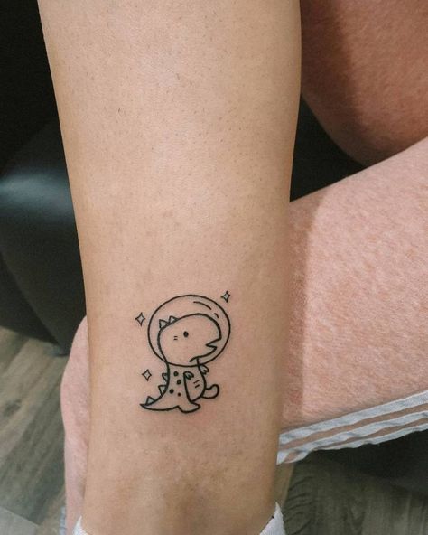 Tattoo Ideas Female Dinosaur, Space Dinosaur Tattoo, Tiny Space Tattoo, Small Dino Tattoos, Dinosaur Tattoos For Women, Tiny Dinosaur Tattoo, Bambi Tattoo, Unique Tattoos Black Women, Space Dinosaur