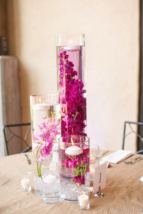 Floating Flowers In Vase, Colorful Candle Wedding Centerpieces, Pink Candle Centerpieces, Flowers In Water Centerpieces, Floating Votive Centerpiece, Turquoise Decorations Party, Candles In Water, Pink Centerpiece Ideas, Flowers Submerged In Water Centerpieces