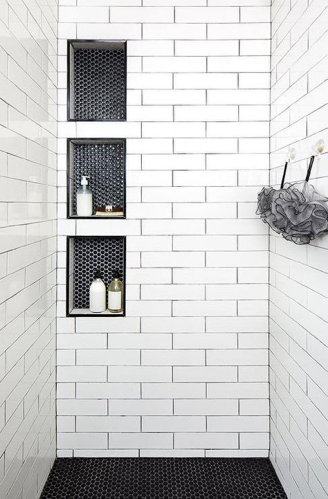 Triple stacked shower niches with black hexagon tiles surround long white shower tiles with black grout creating a unique and stylish walk-in shower design. White Shower Tile, Design Interior Baie, Tiled Shower, Decor Baie, Bad Inspiration, Shower Niche, Master Bath Remodel, White Shower, Bathroom Remodel Shower