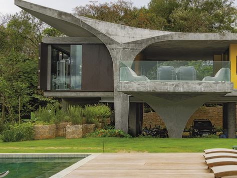 A las afueras de São Paulo, en el corazón de la selva brasileña, Leo Romano ha proyectado 'Casa mais linda', todo un homenaje a las curvas, al brutalismo y al color con inspiración de la arquitectura modernista brasileña. House On Stilts, Unusual Home, Unusual Homes, Concrete House, Concrete Structure, Structure Architecture, Reinforced Concrete, Beautiful House, Mid Century House