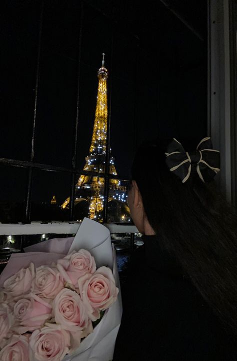 Girl sitting in front of Eiffel Tower at night holding pink roses with a beige and black bow in her hair Paris Birthday Aesthetic, Birthday In Paris Aesthetic, Birthday In Paris Photos, Eiffel Tower Photoshoot, Birthday In Paris, Parisian Birthday, Paris Photo Ideas, Bow Outfit, Night Paris