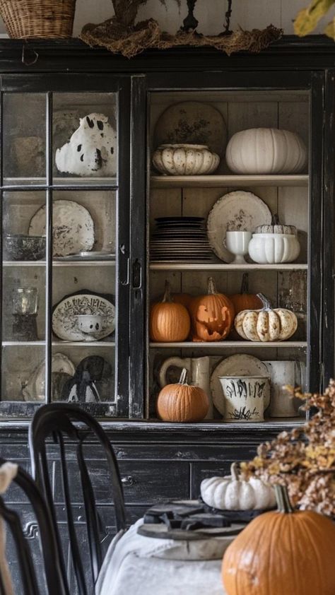 Create a hauntingly cozy kitchen with charming Halloween decor. Hang a banner of felt bats across the window. Display mason jars filled with candy corn and other Halloween treats on open shelves. Add pumpkin-shaped salt and pepper shakers to the dining table. Place a Halloween-themed doormat at the kitchen entrance. Use orange and black striped dish towels for a festive pop of color. Arrange a centerpiece of white pumpkins and fall leaves on the kitchen island. These warm and inviting touches wi Southern Halloween Decor, Halloween Kitchen Island Decor, Haunted Kitchen, Felt Bats, China Hutch Decor, Kitchen Entrance, Hutch Decor, China Hutch, Kitchen Island Decor