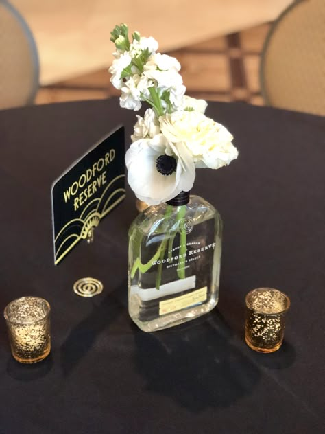 We used multiple bourbon bottles as vessels, for this great Gatsby inspired wedding. Speakeasy Wedding Centerpiece, Bourbon Event Decor, Bourbon Wedding Centerpieces, Bourbon Bottles Wedding, Bubbles And Bourbon Party, Whiskey Themed Centerpieces, Bourbon Wedding Decor, Bourbon And Bubbles Party Decor, Whiskey Bottle Wedding Centerpieces