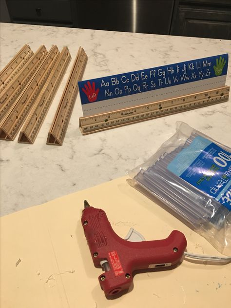 Teacher hack for name plate holders, buy 3 wooden rulers and hot glue to form a tent.  I placed two credit cards in middle while glue dried.  Now I can fit two name plates in there😄. Ran me 75 cents per name plate holder. Name Tags On Tables Classroom, Name Plates For Table, Name Plate Holders Classroom Diy, Diy Name Plates For Desk, Desk Name Plates Diy, Diy Name Plate, Child Care Center Design, Burlap Classroom, Kindergarten Decor