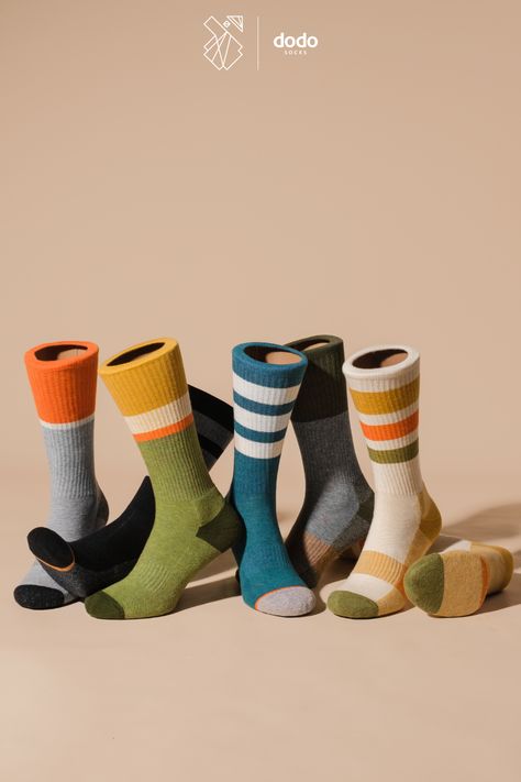 Photo of seven mannequin legs wearing various socks with consistent style and high elastic bands on a beige background. Sock colors from left to right: 1- gray/orange/black, 2- black/gray/red, 3- khaki/green/yellow/beige/orange, 4- navy/white/orange, 5 and 6- gray/green, 6- beige/yellow/orange/green. Sock Photography, Hippie Outfits Men, Socks Photoshoot, Socks Photography, Ukrainian Culture, Mens Socks Fashion, Socks Design, Sock Design, Socks Packaging