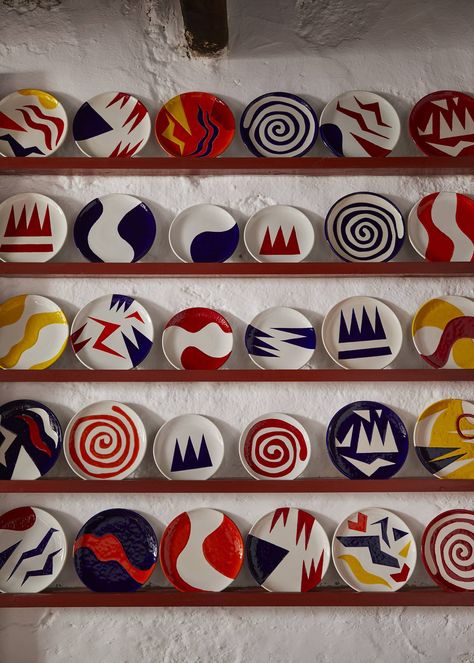 A plate rack displays a collection of Teddy Millington-Drake’s ceramic plates in primary colors. Blue Shelves, Cotton Mattress, Plate Rack, Textile Designer, Painted Plates, Hand Painted Plates, Ceramics Pottery Art, Plate Art, British Artist