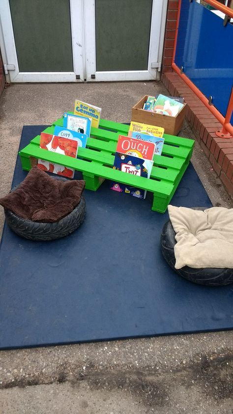 Reading area outdoors with a pallet Outdoor Areas For Preschool, Indoor Outdoor Classroom, Pallet Outdoor Play, Classroom Outdoor Area, Outdoor Play Eyfs, Outside Classroom Ideas Outdoor Spaces, Day Care Outdoor Play Areas, Outside Areas Eyfs, Eyfs Outside Area Ideas