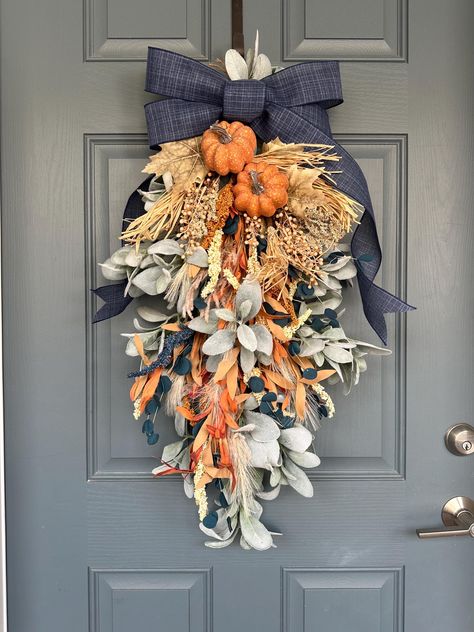 Want to see what it would look like on your door before purchasing? Message me a picture of your empty door and I can show you an example! This beautiful swag will be the perfect touch for your door, double doors, columns, wall, etc. Made with quality faux lamb's ear, orange pumpkins, fall florals, and wired navy ribbon bow. Hangs easily.  Bow available in burlap, blue/orange checkered plaid (shown in listing pics), black, orange/white plaid, burlap/white stripes, and many more options! Please n Fall Decor Blue And Orange, Fall Decor With Blue Accents, Swags And Wreaths, Fall Swags For Front Door, Navy Blue Fall Decor, Navy Fall Decor, Blue And Orange Fall Decor, Teal Fall Decor, Orange Fall Decor