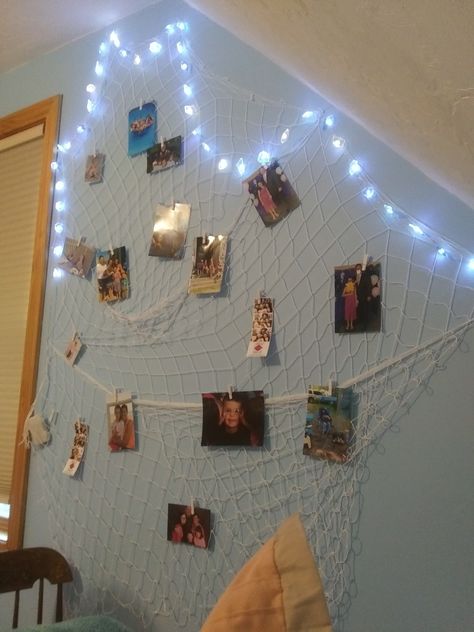 This is fish net hung up with clear push pins. Use fairy lights around it and some clip for the pics Fish Net Decor Bedroom, Room Aestethic, Beach Dorm, Fish Net Decor, Picture Room Decor, Beach Room Decor, Ocean Room, Dorm Inspo, Beach Room