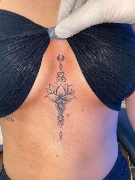 Tattoo Ideas On Sternum, Neck And Shoulder Tattoos Black Women, Sternum Tattoos Black Women, Women’s Underboob Tattoo, Lotus Flower Tattoo Under Breast, Underboob Lotus Tattoo, Lotus Flower Tattoo Between Breast, Womens Underboob Tattoo, Flower Between Breast Tattoo