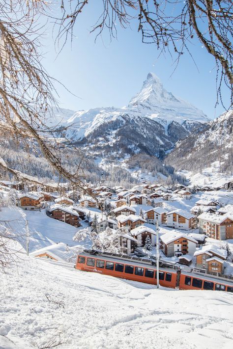 Zermatt is a stunning ski resort in Switzerland. With a reliable snow sure record and high altitude, it makes a great destination for late season Easter April spring ski holidays. The village itself is very pretty, with lots of traditional Swiss chalet style architecture and buildings. The resort is car-free, and only accessible by scenic mountain train. All under the shadow of the stunning Matterhorn mountain peak Skiing In Zermatt, Zermatt Skiing, Snow In Switzerland, Christmas In Switzerland, Snow Switzerland, Skiing In Switzerland, Christmas Mountains, Switzerland Skiing, Switzerland Snow