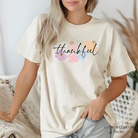 Thankful Boho T-Shirt Bible Verse Shirt. Minimalist Christian Faith Tee makes a thoughtful gift for friends. Self Affirmation Spiritual Spring Floral Shirt. Cute Comfort Colors Tshirt for women.  Express gratitude in style with this Thankful Boho Flowers Christian T-Shirt, a perfect blend of faith, self-love, and minimalist floral beauty. Featuring delicate hand-drawn boho flowers in soft spring-inspired hues, this Comfort Colors tee is a gentle reminder to live with a thankful heart. 🌿 Why You'll Love This Shirt: ✔️ Faith-Inspired Message - Perfect for daily wear or gifting. ✔️ Boho Minimalist Design - A timeless floral aesthetic with soft, neutral colors. ✔️ Comfort Colors Quality - Premium soft-washed, 100% ring-spun cotton for all-day comfort. ✔️ Perfect Easter & Spring Tee - Celebrat