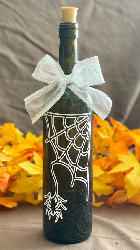 This cute Halloween Wine Bottle with a spider hanging from his web has a hard time looking spooky! But he will certainly put you with holiday spirit. These bottles are so popular and fun and make great decorations, housewarming gifts, teacher gifts, etc. Bottles are decorated with colorful quality vinyl and cork lights have multiple settings. We always include an extra set of batteries with each bottle purchase. Another great addition to your fall decoration collection. Crown Royal Diy, Halloween Wine Bottle Crafts, Holiday Crafts Halloween, Halloween Wine Bottles, Repurposed Wine Bottles, Halloween Bottles, Halloween Wine, Bottle Diy, Wine Glass Crafts