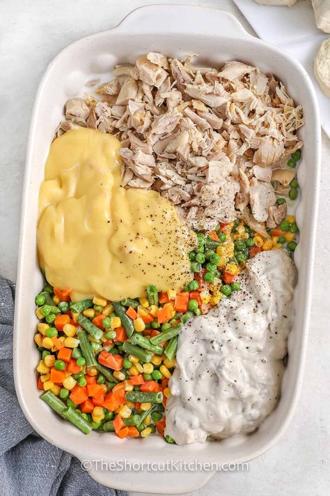 Craving comfort food? This easy chicken pot pie recipe is just what you need! Shredded chicken, mixed veggies, and creamy soups make up the filling, while golden biscuits top off this hearty casserole. The garlic butter brushed on top adds a flavorful touch, making it a dish your family will ask for again and again. Just a few simple steps for a cozy meal that satisfies! #theshortcutkitchen Dinner Idea With Shredded Chicken, Casseroles With Leftover Chicken, Dinner Recipe With Shredded Chicken, Chicken Pie Cobbler, Crockpot Recipes Chicken Pot Pie, Precooked Shredded Chicken Recipes, Recipes For Precooked Chicken, One Pot Shredded Chicken Recipes, Chicken Pot Pie Rice Casserole