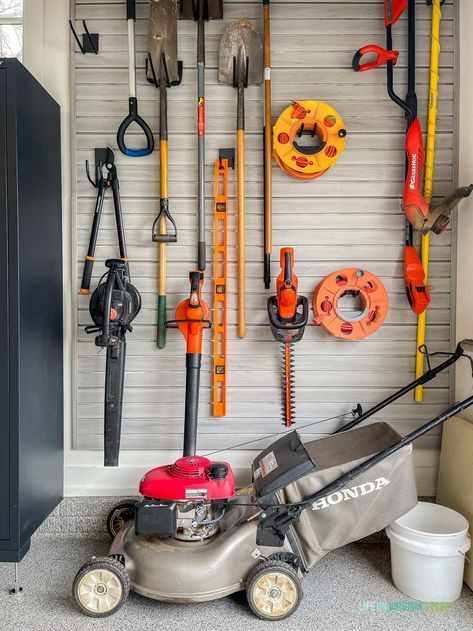 Gardening tools stored on a garage slat wall to keep the garage organized. Garage Organization Ideas Yard Tools, Lawn Tools Storage Ideas, Gardening Tools Organization, Flow Wall Garage Storage, Garage Slat Wall Organization, Garage Slat Wall, Garage Wall Organization, Garden Tool Storage Ideas, Garden Storage Ideas