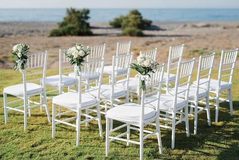 White Tiffany chairs decorated for wedding ceremony.  Chania villa. Wedding planner www.creteforlove.com.  Photographer www.amarkakis.com White Chiavari Chairs Wedding Ceremony, White Tiffany Chairs Wedding Ceremony, Beach Wedding Ceremony Chairs, White Tiffany Chairs Wedding, Tiffany Chairs Wedding, Chiavari Chairs Wedding, Tiffany Chairs, Wedding Ceremony Chairs, Chairs Wedding