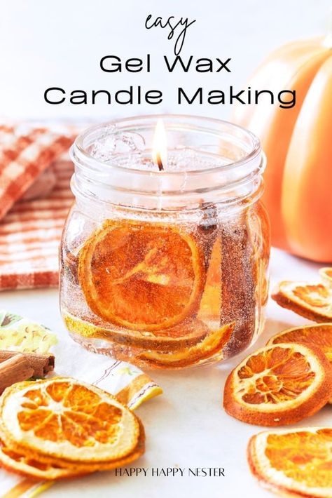 An image showcasing a lit candle in a glass jar with dried orange slices embedded in the gel wax. The text reads "Easy Gel Wax Candle Making." There are additional dried orange slices and a striped cloth in the background. The source is noted as "Happy Happy Nester. Gel Wax Candles Diy, Simple Fall Crafts, Gel Candle Diy, Wax Candle Making, Gel Wax Candles, Diy Cinnamon, Fall Crafts For Adults, Wax Candles Diy, Candle Printable