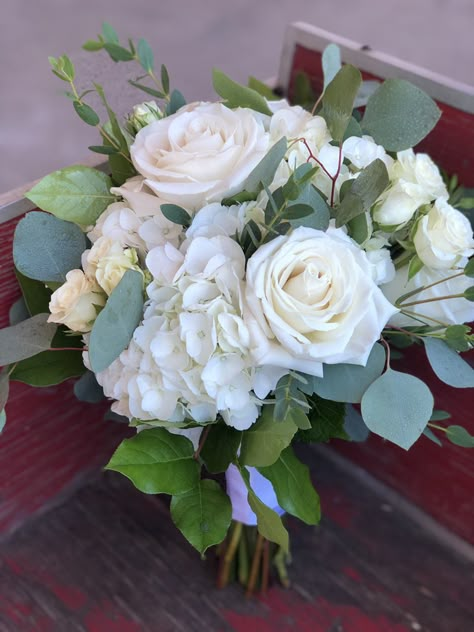 Playa Blanca rises, white hydrangea, spray roses and silver dollar eucalyptus in a handtied bridal bouquet White Rose And White Hydrangea Bouquet, Hydrangea And Rose Wedding Bouquet, Hydrangea And Rose Bouquet With Greenery, Prom Bouquet Ideas White Roses, White Rose Hydrangea Eucalyptus Bouquet, Bridesmaid Bouquet With Hydrangeas, White Hydrangea Bouquet With Greenery, Cream Hydrangea Bouquet, Bouquet Hydrangea White