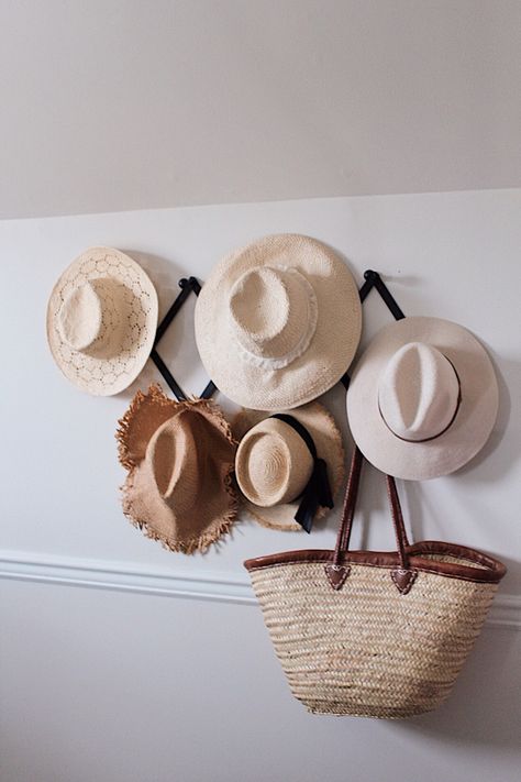 Nothing cuter than using straw hats and bags to fill a blank wall! So simple and easy to do with a hat rack or just nails! Need ideas on what to do with a blank wall in your home? Straw HAT WALL! Easy and attainable home decor to try in 2020. #hatwall #walldecor #homedecor #homedecorideas #strawhat #wallhanging #wallart #hatfashion #farmhousebedroom #interiordecor #interiordesignideasbedroom Bedroom Hat Wall, Hats Photoshoot, Basket Wall Ideas, Straw Hat Wall, Bali Bedroom, Hat Displays, Boho Beach House, Hat Decor, Inexpensive Art