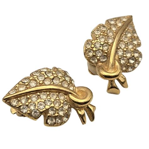 These Givenchy earrings encapsulate the opulence of vintage fashion with their exquisite leaf design. The shimmering rhinestones on a gold-tone base make these clip-on earrings a chic accessory to adorn any attire, echoing timeless elegance and luxury. * Clip-on closure   * Rhinestone embellishments   * Leaf design   * Gold-tone metal   * Vintage Givenchy * Minor wear consistent with age and use   * Approximately 1 inch in length Nice Estate Condition Measurement: Approx. 1 " x 3/4 " A Great Addition To Any Collection Or Wardrobe Nice Gift Idea or Gift To Yourself ! Givenchy Earrings, Vintage Givenchy, Sparkle Jewelry, Chic Accessories, Leaf Design, Gold Tone Metal, Clip On Earrings, Givenchy, Timeless Elegance