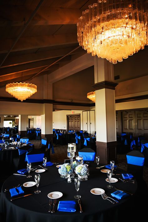 Traditional Wedding Reception Décor with Black Tablecloths, Royal Blue Chair Covers and Napkins with Blue and Ivory Hydrangea Centerpieces at Countryside Country Club Wedding Venue | Limelight Photography Blue And Black Wedding Venues, Black And Blue Decorations Parties, Blue White And Black Wedding Theme, Black And Blue Table Decor, Blue Wedding Black People, Blue And Black Quinceanera, Black And Sapphire Blue Wedding, Sapphire And Black Wedding Theme, Royal Blue Black And Silver Wedding Table Settings