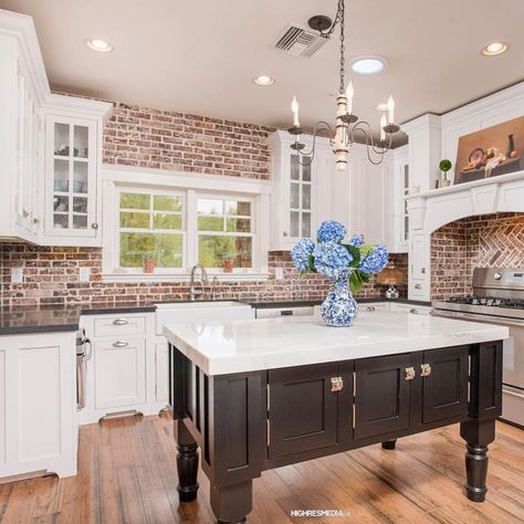 There’s nothing like a kitchen with exposed brick. In this farmhouse kitchen by @highresmedia the white trim and cabinets offset the… White Marble Island, Kitchen With Exposed Brick, Brick Kitchen Wall, Exposed Brick Kitchen, Brick Wall Kitchen, Wood Shelves Kitchen, Brick Backsplash Kitchen, American Farmhouse Style, Farmhouse Industrial