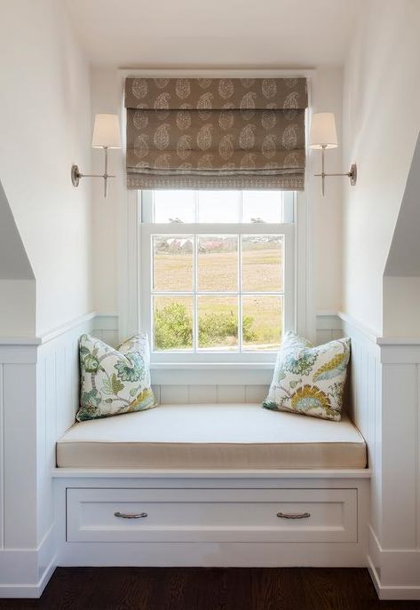 A brown paisley block print roman shade hangs from a window between facing Thomas O'Brien Bryant Sconces and over a white built-in window seat. Bedroom Window Alcove Ideas, Attic Bedroom Window Seat, Dormer Window Built Ins, French Country Bay Window, Window Seat With Sconces, Window Seat In Dormer, Dormer Window Storage Bench, Dormer Bench Seat, Dormer Window Seat Ideas